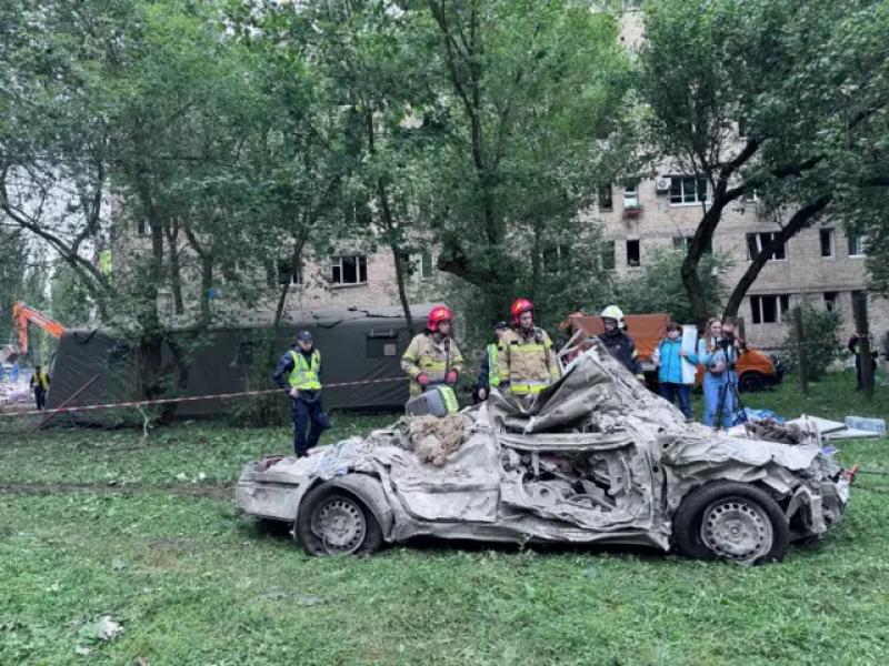 Рятувальники забирають пошкоджені авто від обваленого будинку 