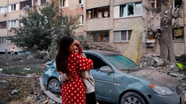 Жінка втішає плачучу дівчинку біля пошкодженого авто