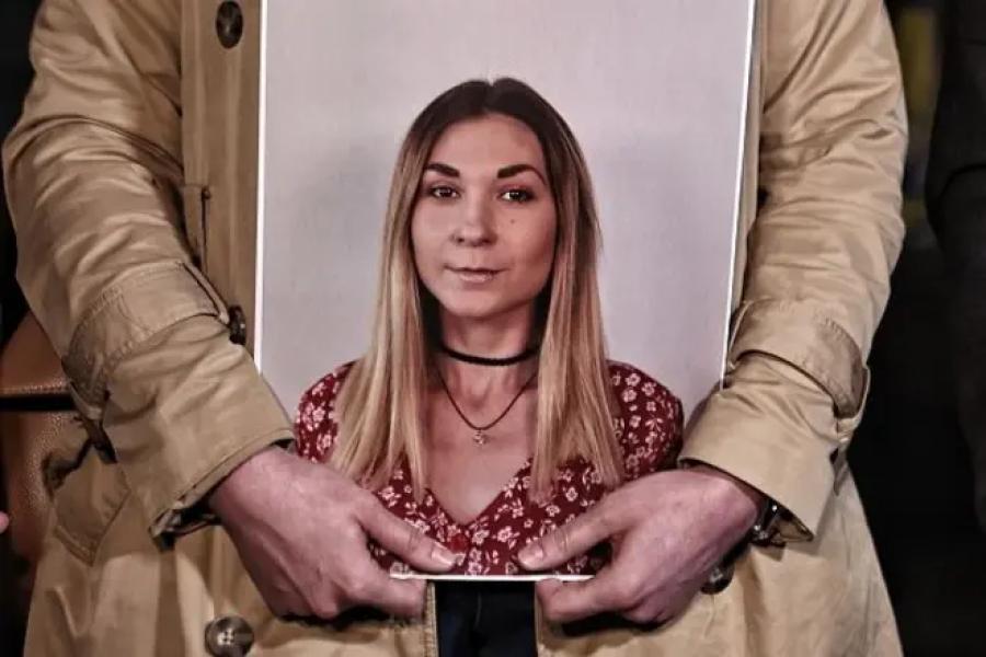 Людина тримає портрет української журналістки Вікторії Рощиної під час вшанування її пам'яті. Жовтень 2024