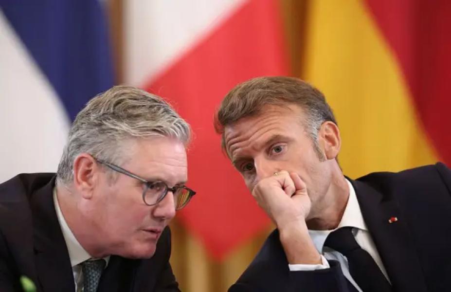 Кір Стармер та Еммануель Макрон розмовляють на тлі прапорів
