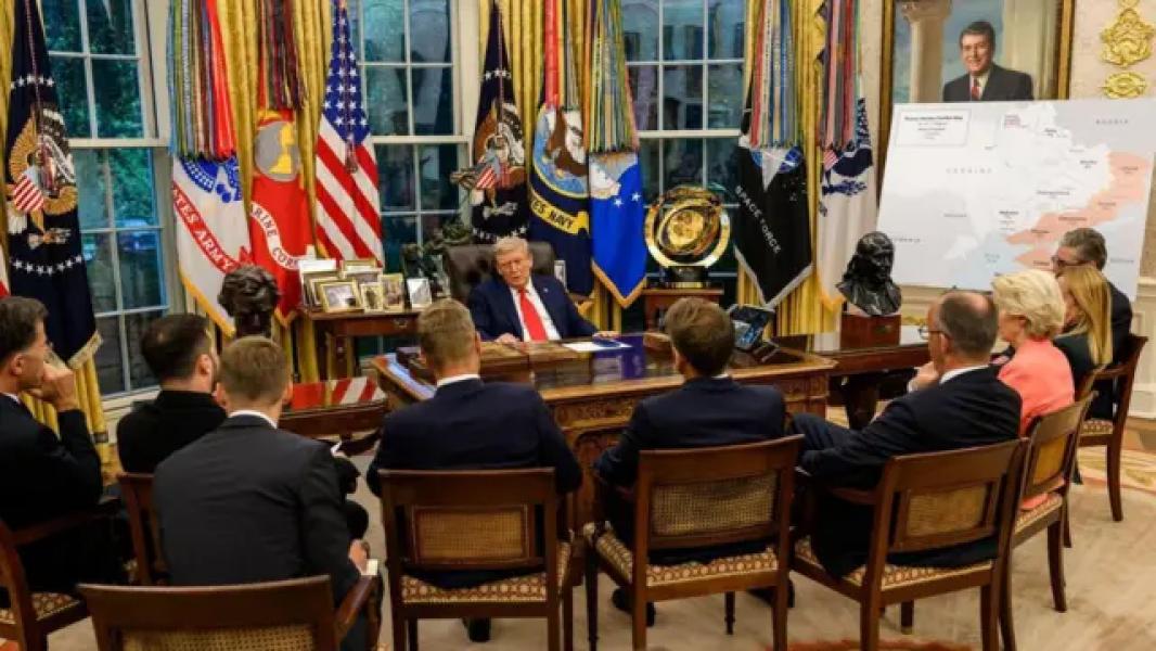 Трамп за столом в овальному кабінеті, навпроти нього спинами до глядачів сидять на стільцях європейські лідери та Зеленський, праворуч стоїть велика мапа України з окупованими територіями