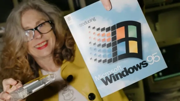 Жінка тримає упаковку він Windows 95 та упаковку дискет