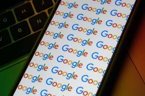 Крупний план мобільного телефону, на екрані якого повторюється слово «Google».