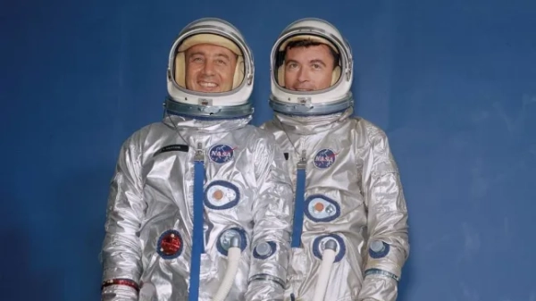 Члени екіпажу Gemini III, Вірджил I. «Гас» Гріссом (ліворуч) та Джон В. Янг, одягнені у скафандри, шоломи та портативні кондиціонери.
