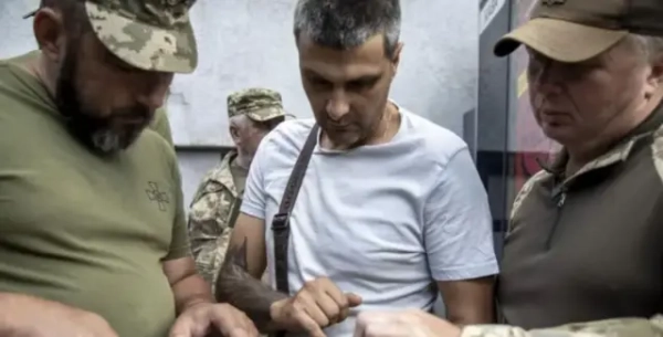 Працівники ТЦК перевіряють документи в чоловіка на телефоні