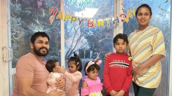 Данушка Вікрамасінге, його дружина Даршані Еканаяке та четверо дітей стоять біля вікна, на якому висить гірлянда &quot;З днем народження&quot;