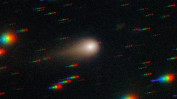 На цьому зображенні, отриманому за допомогою багатооб&#39;єктного спектрографа Gemini (GMOS) на південному зоряному супутнику Gemini у Серро-Пачан у Чилі, що є частиною Міжнародної обсерваторії Gemini, частково фінансованої Національним науковим фондом США (NSF) та керованої NSF NOIRLab, комета 3I/ATLAS пронизує щільне зоряне поле. Це зображення складається з експозицій, зроблених через чотири фільтри - червоний, зелений, синій та ультрафіолетовий. Під час зйомки комета залишається нерухомою в центрі поля зору телескопа. Однак положення зірок фону змінюється відносно комети, через що на кінцевому зображенні вони виглядають як різнокольорові смуги. Дивіться версію зображення, де зірки 