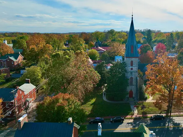 Найкращі та найгірші штати США для виходу на пенсію: рейтинг 108 Вид з повітря на Шерпастаун з вежею невеликої церковної дзвіниці, оточеною осінніми деревами, будинками, вулицями та припаркованими автомобілями.