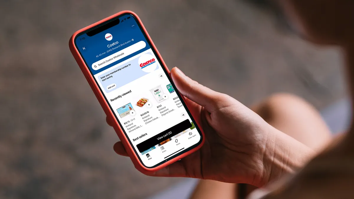 Наближений кадр людини, яка переглядає продукти Costco в додатку Uber.