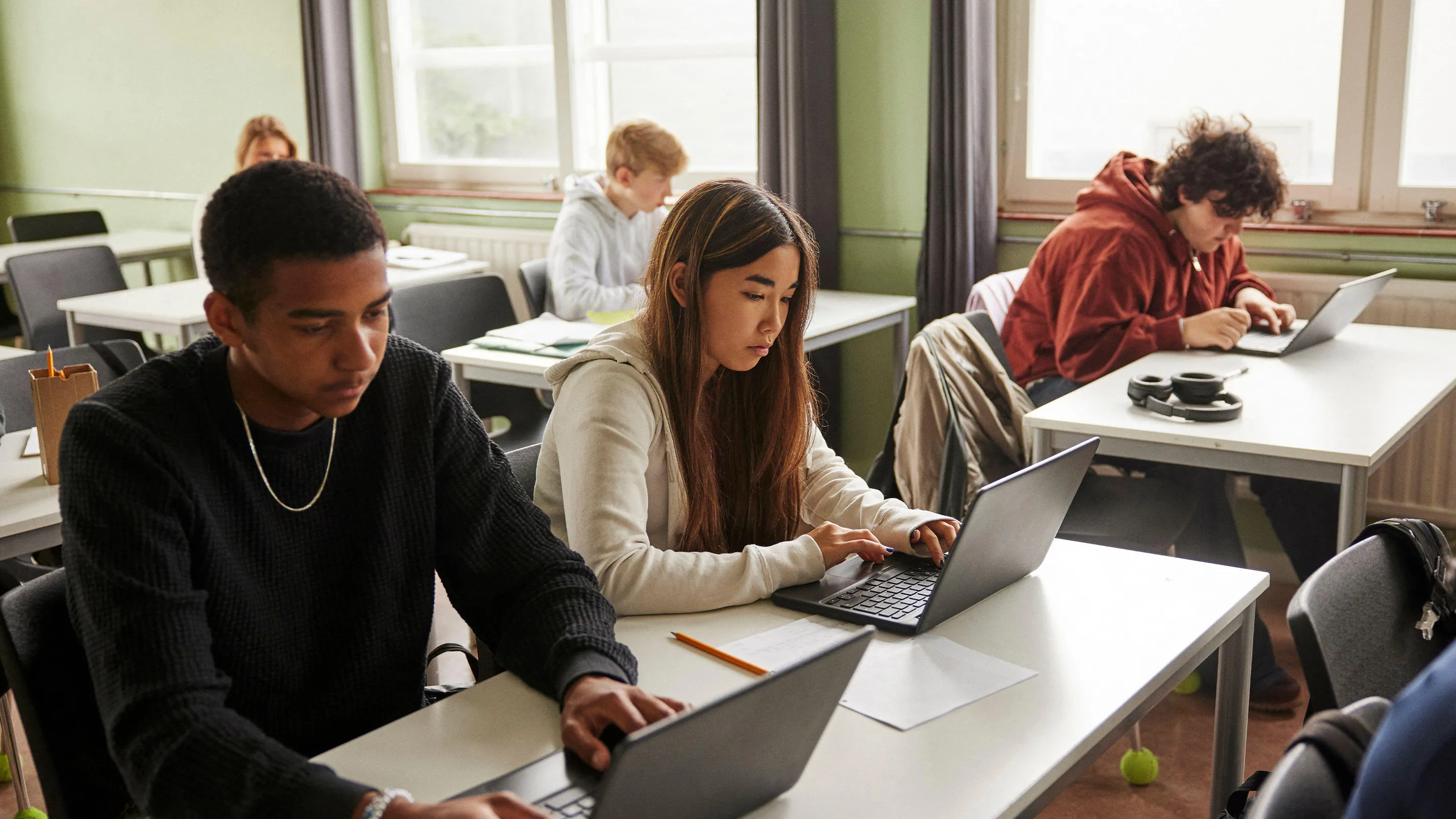 High school students working on laptops in class