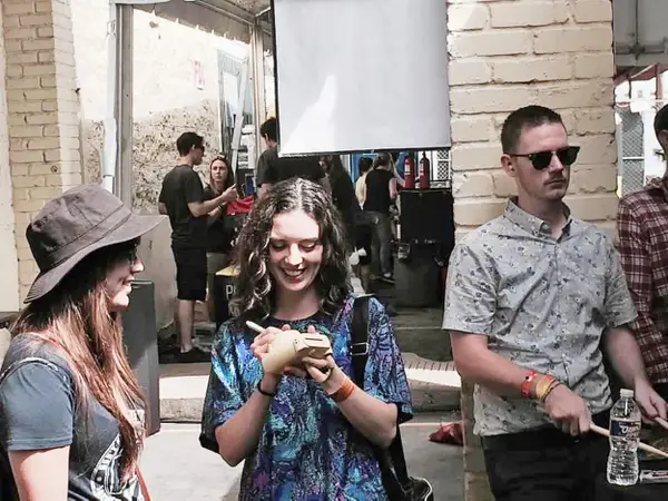 Авторка бере автограф у басиста, поки праворуч практикується барабанщик.