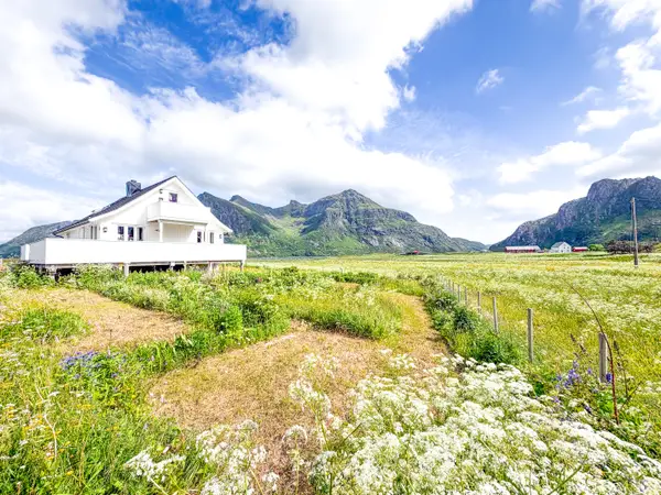 White house surrounded by grass with mountains in distance